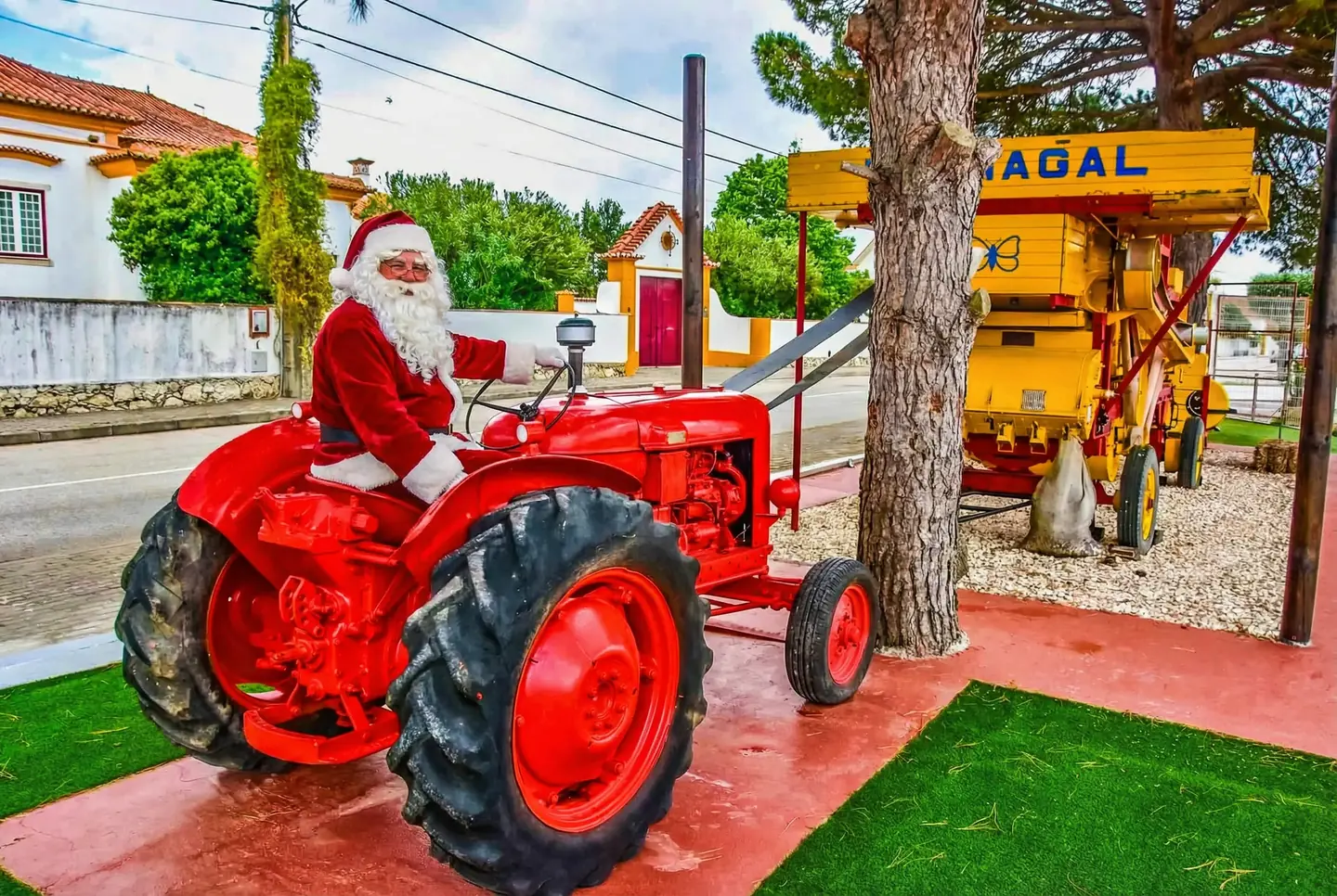 Pai Natal num trator vermelho no jardim